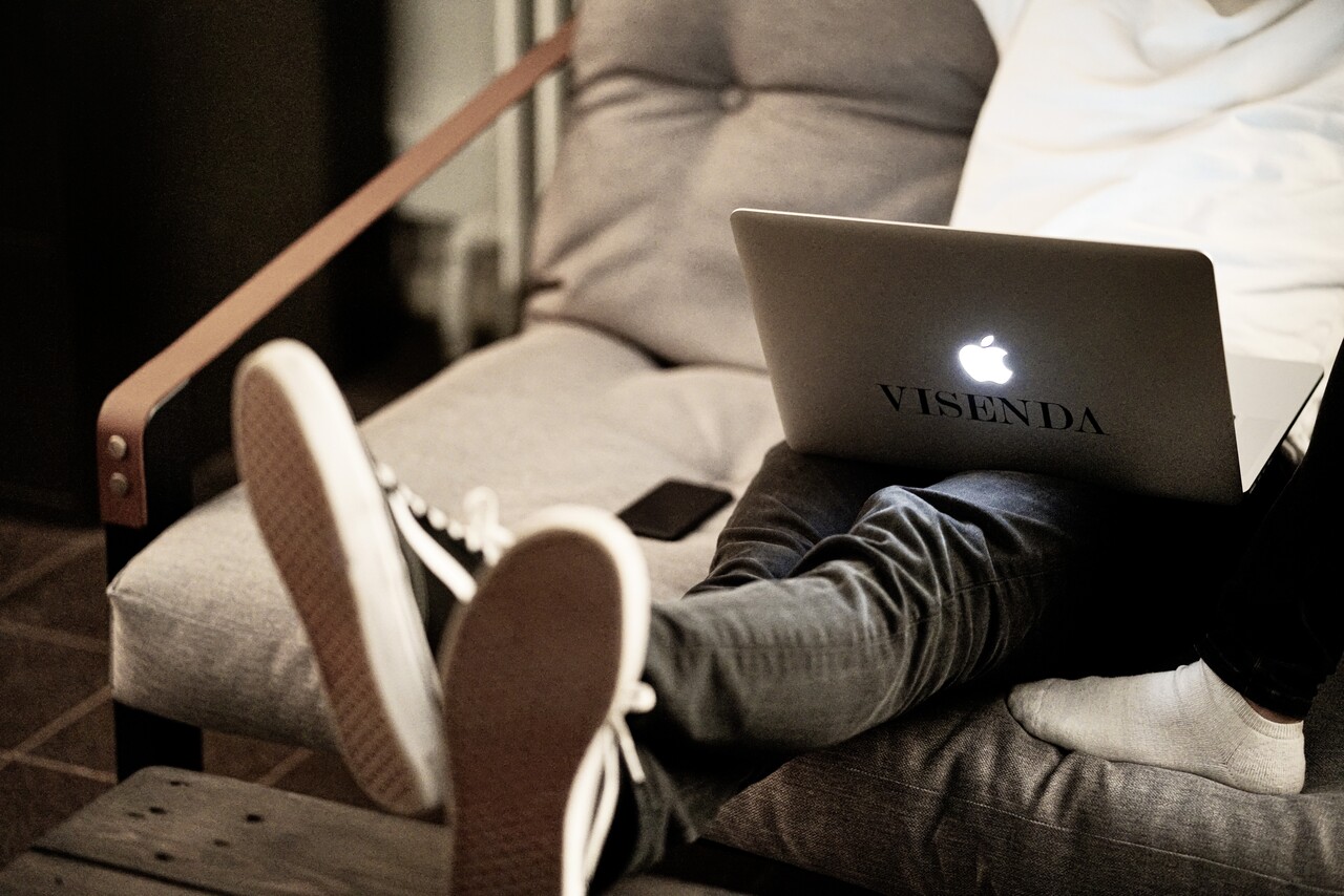 Person sitting on the coach with their Macbook